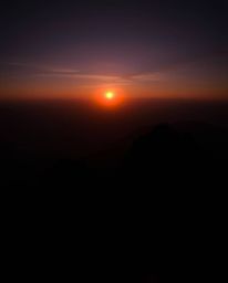 Experience a dreamy atmosphere with this stunning sunset from a high alpine peak, defined by its contrasting chiaroscuro ligh