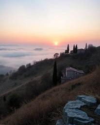 An unusual, original fine art photograph of a Tuscan sunset over misty hills, viewed from a high angle perspective. Soft past
