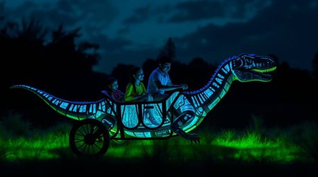 A prehistoric family enjoys a thrilling ride in a bioluminescent dinosaur car.  Intense jet-black glowing colors create drama