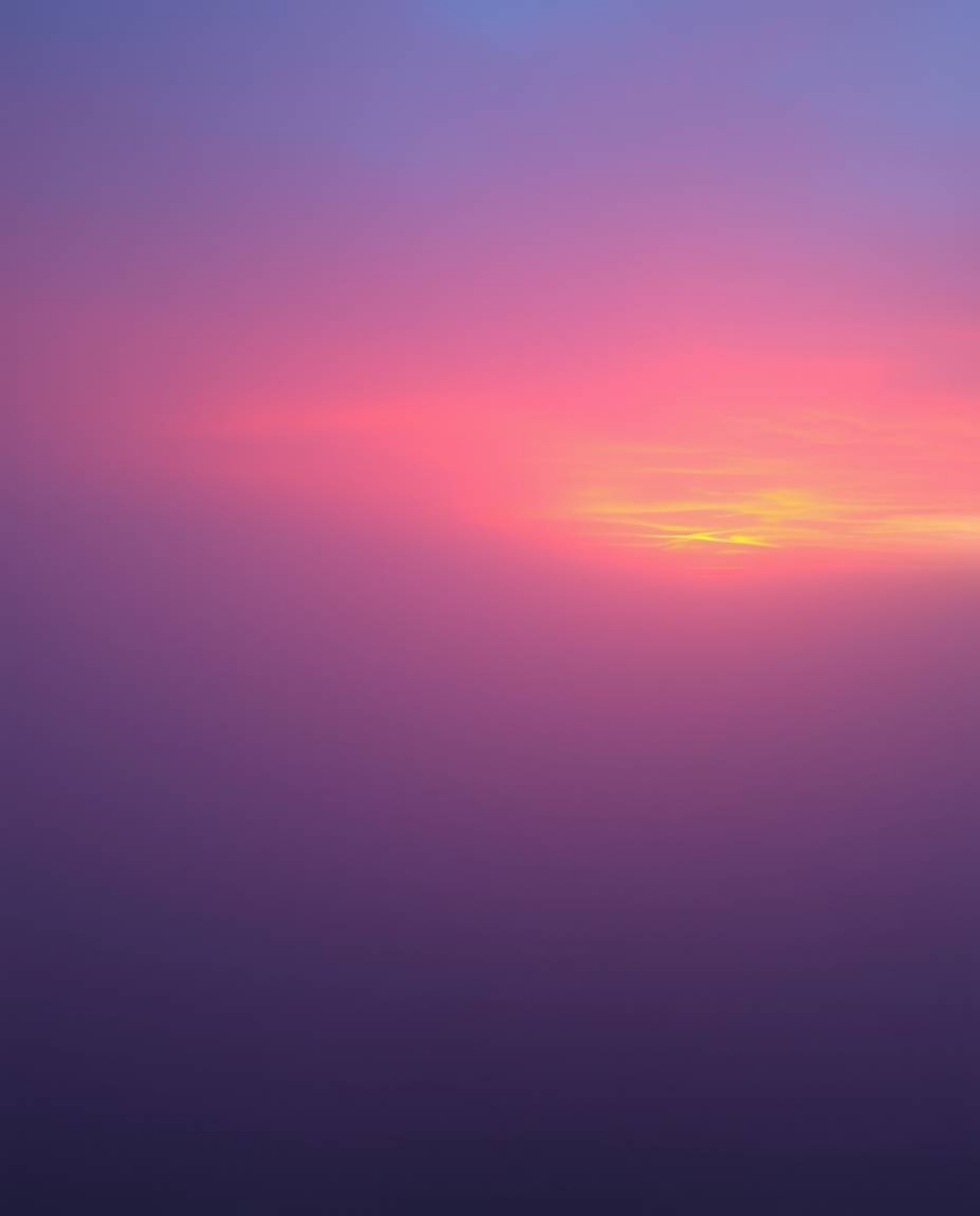 This image captures snowflakes falling during a vibrant sunset, enveloped in thick fog which creates a scene of low visibilit