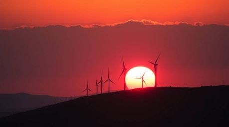 A captivating cinematic photograph depicts a breathtaking sunset casting warm hues of red, orange, and yellow across a hillto