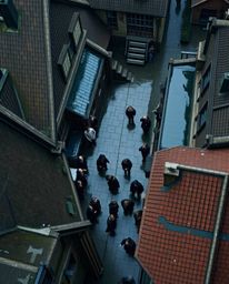 Experience the enchanting atmosphere of a magical school on a rainy day. This captivating overhead view showcases young wizar