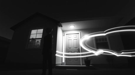 A classic black and white long-exposure photograph depicting an alien residing in a suburban house, skillfully capturing moti