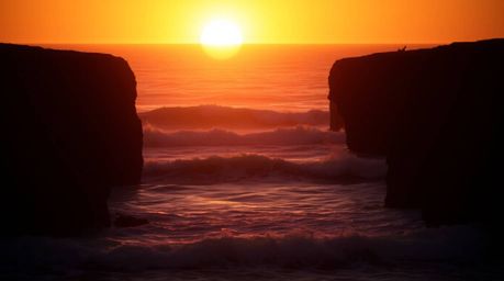 Experience the captivating beauty of professional fine art photography depicting waves crashing against cliffs under a vibran