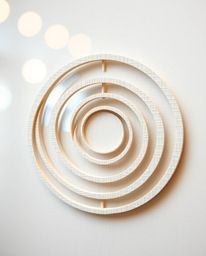 This artwork showcases a minimalist geometric pattern of circles and lines, reminiscent of Bauhaus style.  Sculpted from laye
