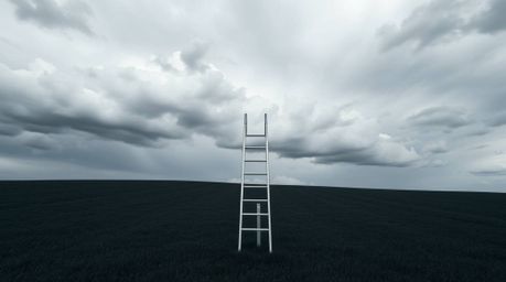 High-resolution stock photo capturing a minimalist scene: a silver ladder stands in an open field beneath a wide, cloudy sky,