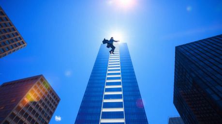 This image represents the abstract concept of success, depicting a graceful businessperson ascending a transparent ladder tha