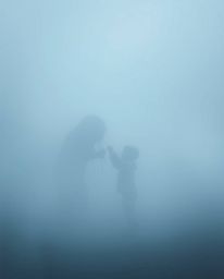 A heartwarming and mysterious scene unfolds in a thick fog, where a child unexpectedly befriends a captivating sea creature.