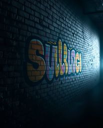 A captivating image showcases vibrant graffiti-style splashes on a brick wall, bathed in soft, diffused light.  The low-contr