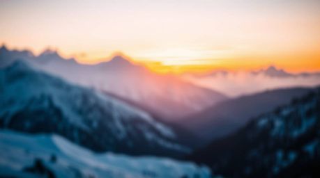 Capture the beauty of snow-covered mountains bathed in the soft glow of a pastel sunset. This image features a blurred bokeh 