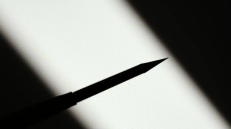 Explore the power of contrasting chiaroscuro lighting in a tight close-up shot, revealing a minimal aesthetic with strong con