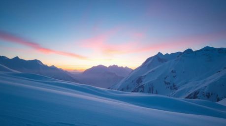 Capture the serene beauty of snow-covered mountains bathed in the gentle glow of a pastel sunset. This image evokes a sense o