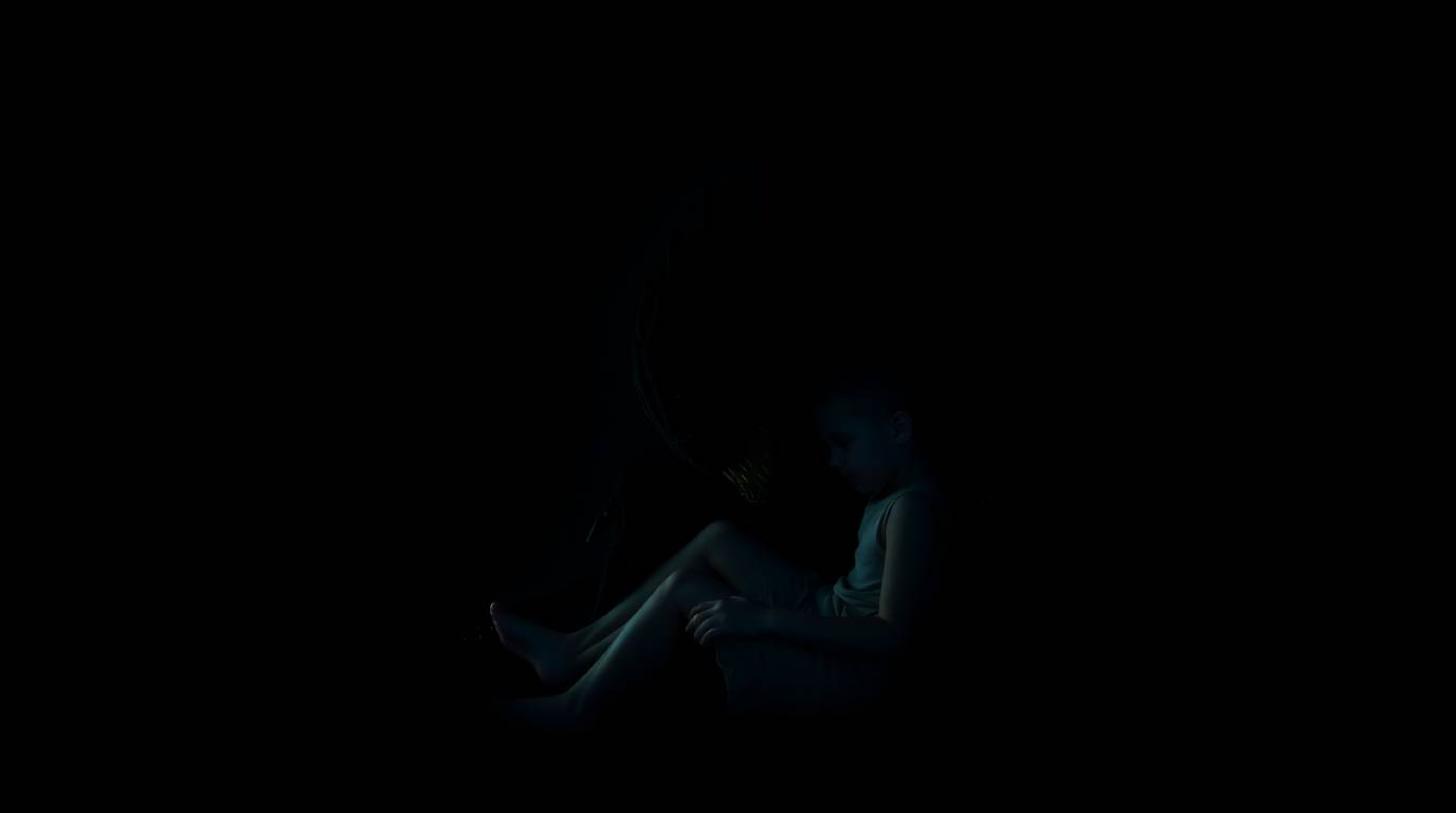 A captivating fine art photograph depicting a unique bond between a child and a monster under the bed.  The image features in