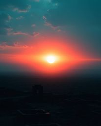 A captivating image of a sunrise over a war-torn landscape, showcasing a rich, deep teal color palette. The scene evokes an e