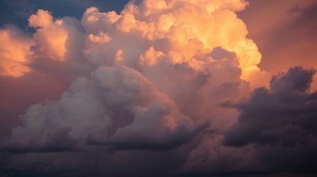 A captivating long-exposure photograph reveals the dramatic beauty of thunderstorm clouds ignited by the vibrant hues of a su