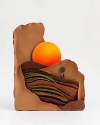 A layered papier-mâché sculpture of a sunset over terraced tea plantations. This piece is characterized by its textured surfa
