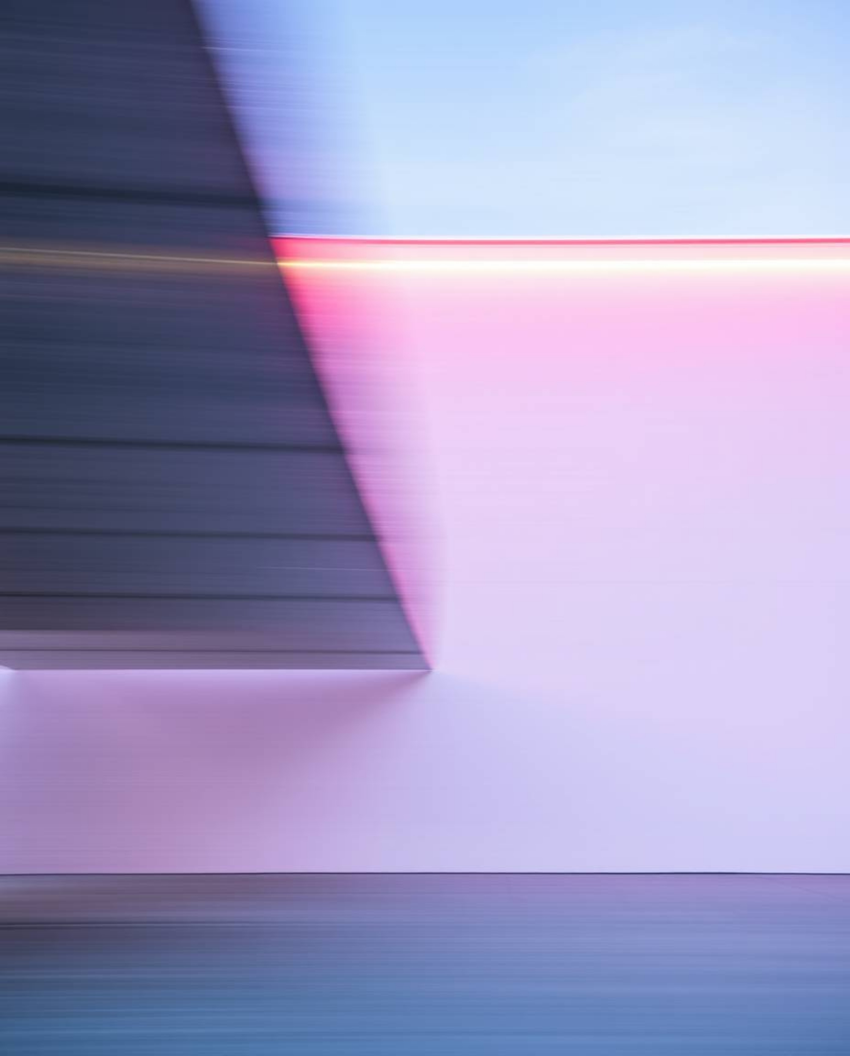 This architectural photograph captures dynamic motion through a striking interplay of blurred and sharp lines. Detailed struc