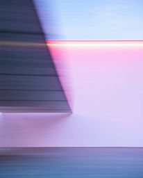 This architectural photograph captures dynamic motion through a striking interplay of blurred and sharp lines. Detailed struc