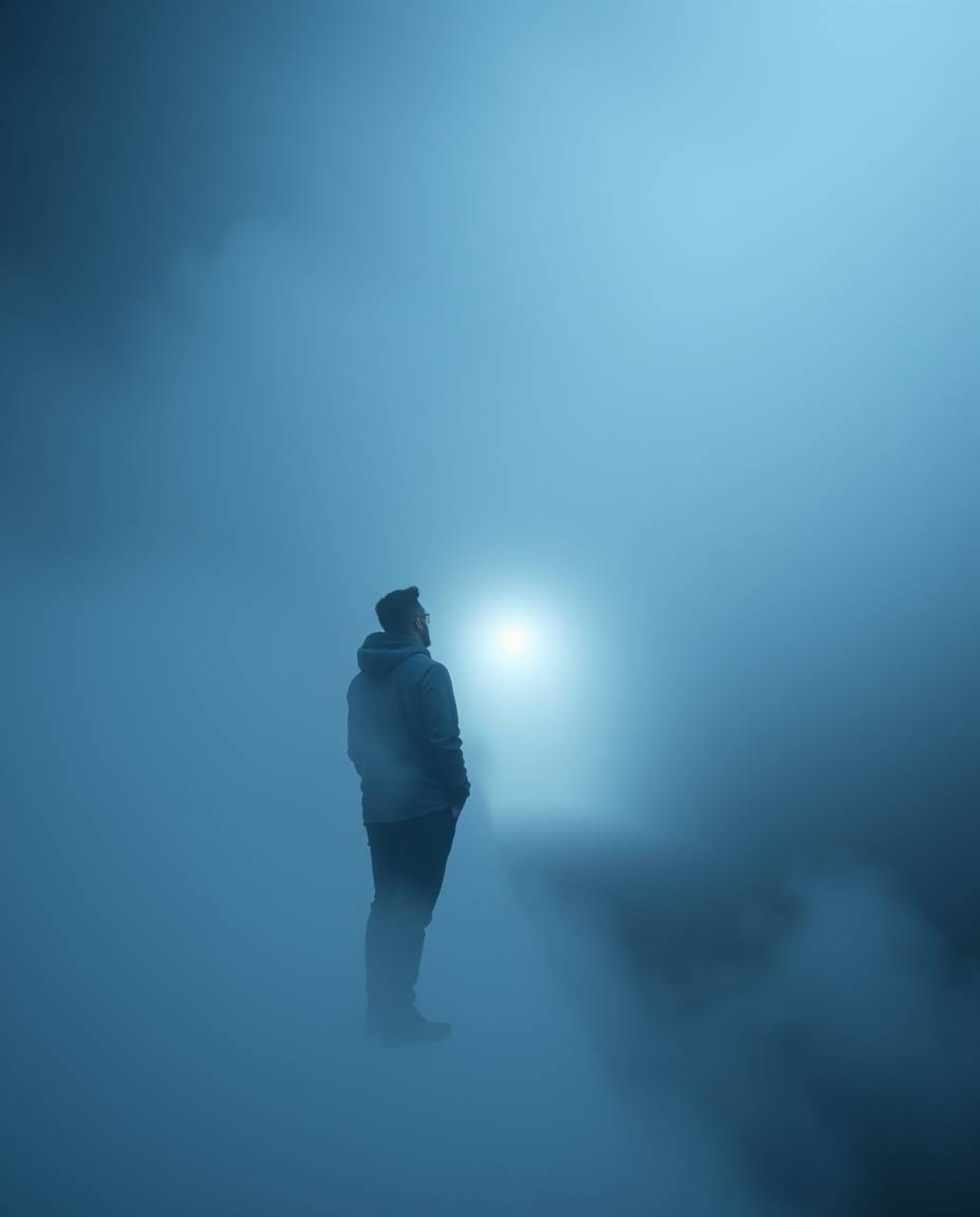 A captivating high-resolution stock photo depicts a person partially obscured by thick fog, standing at the edge of a tunnel 