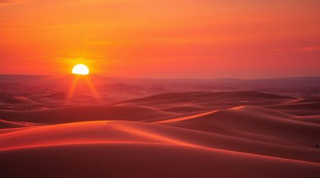 Capture the breathtaking beauty of a vibrant sunset over golden desert dunes.  This stunning image showcases seamless color b