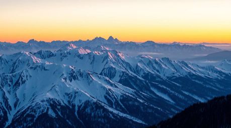 A stunning high-resolution stock photo captures the breathtaking beauty of snow-covered mountains bathed in the warm glow of 