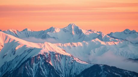 Experience the serene beauty of snow-capped mountains illuminated by a pastel sunset. This image evokes a dreamy atmosphere, 
