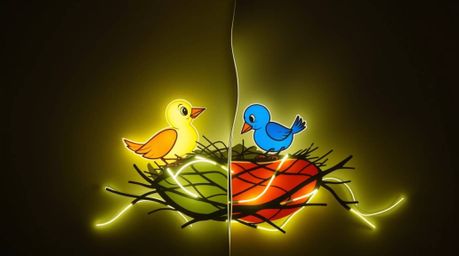 A captivating light art piece showcases two cartoon birds constructing a nest, rendered in a classic animation style. The ar