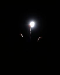A captivating image showcasing a hand reaching from profound darkness towards a beckoning light source. The scene is characte