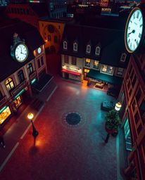 A captivating high-angle perspective of an empty town square bathed in glowing bioluminescent colors. The scene features the 