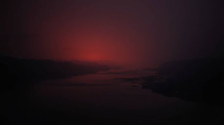 An eerie, warm-toned fine art photograph of a river delta glowing in twilight colors, reminiscent of Associated Press photogr