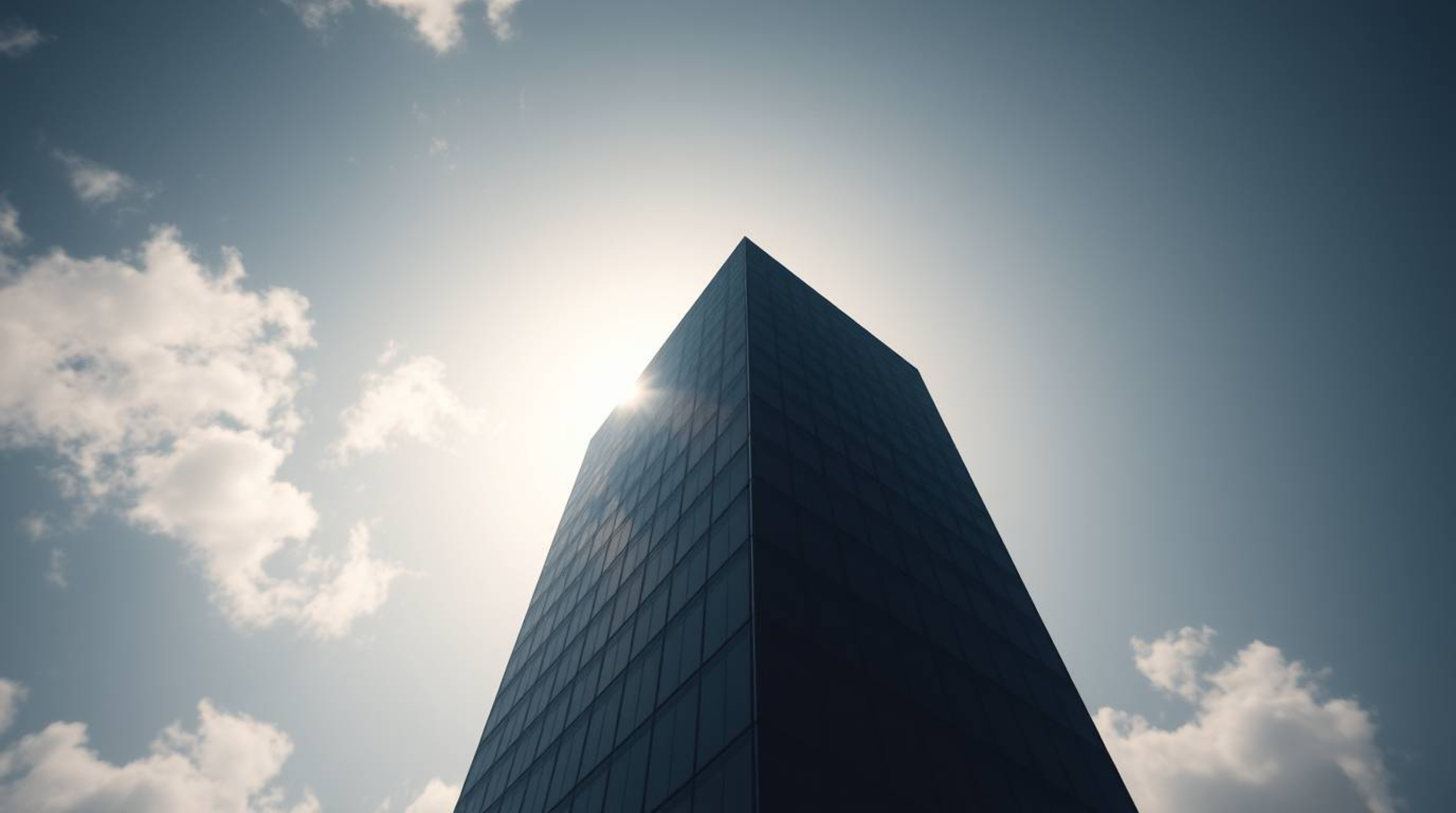 This captivating image features a modern glass building silhouetted against a sky filled with soft, dissolving clouds, employ