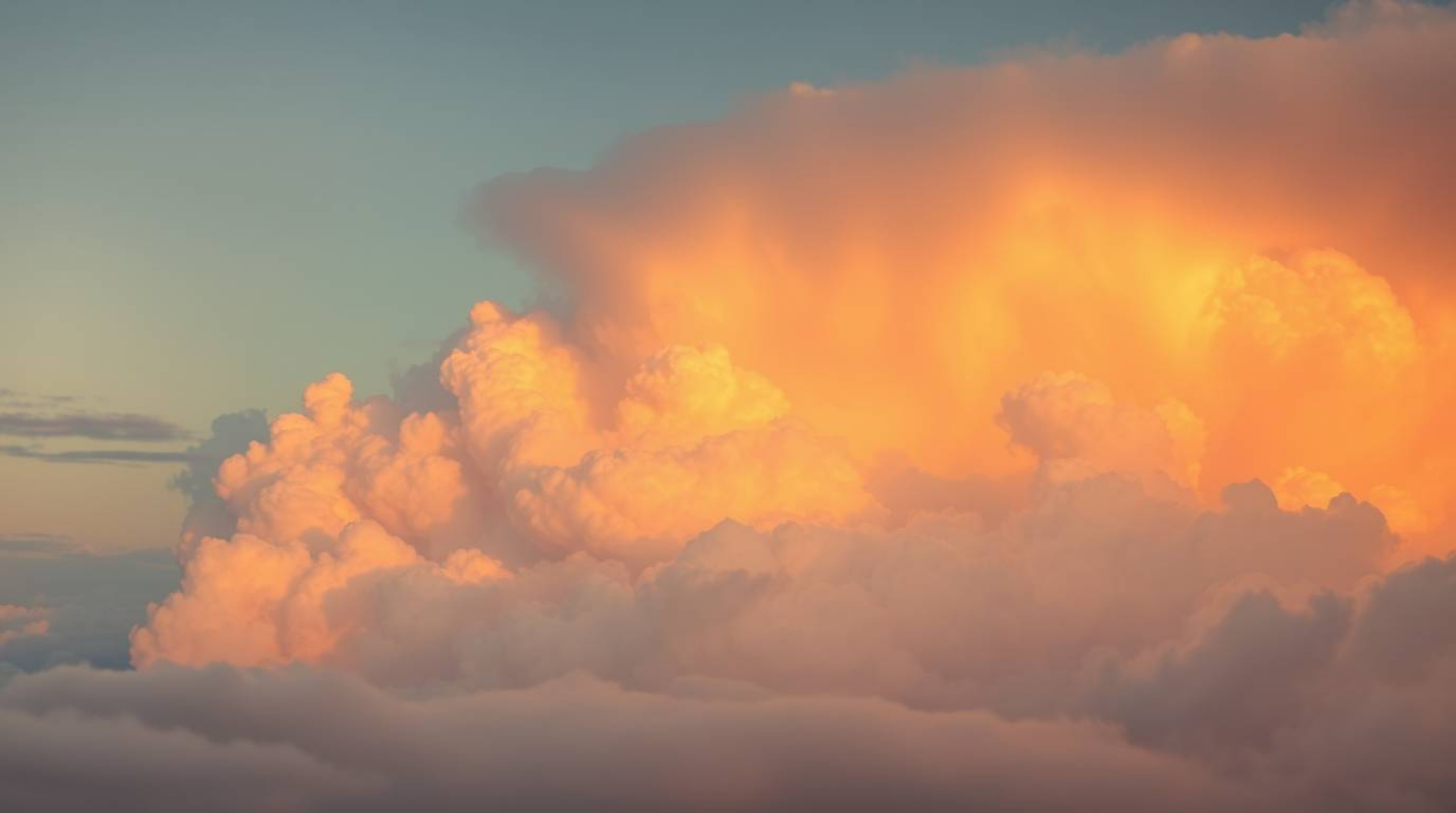 Experience the ethereal and spiritual with this depiction of thunderstorm clouds bathed in the soft, warm glow of golden hour
