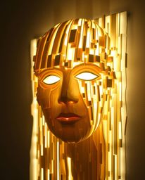 A captivating light art piece transforms a human face into a mesmerizing data stream using layered papier-mâché.  The artisti