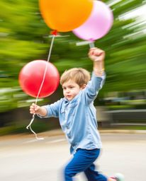 This image captures a child in a dynamic action shot, joyfully holding a balloon. The artwork is rendered in bright, vibrant 