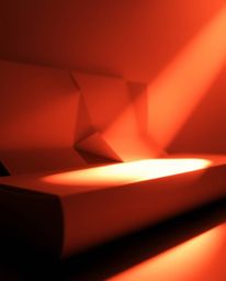 A captivating monochrome image depicts a warm golden hour light illuminating a 3D geometric pattern reminiscent of folded pap