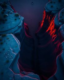 A cool-toned, overhead bird's-eye view captures a sunset illuminating sandstone cliffs. From this top-down perspective, the c