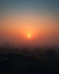 A captivating image depicting a sunrise over a war-torn landscape, rendered with a soft cinematic haze and dreamy atmosphere.