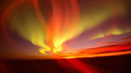 Explore the captivating beauty of warm, dynamic creative light art, showcasing northern lights gently emerging over a breatht