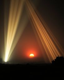 A precise architectural color photograph captures a breathtaking sunrise over a war-torn landscape.  Volumetric lighting crea