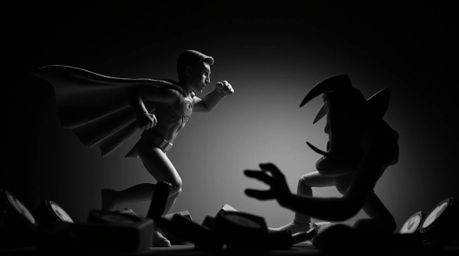 An intense scene unfolds as a sculptural clay superhero, cape dramatically billowing in the wind, battles a comically exagger