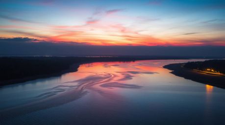 Experience the breathtaking beauty of a river delta bathed in the warm glow of twilight. This stunning image showcases vibran