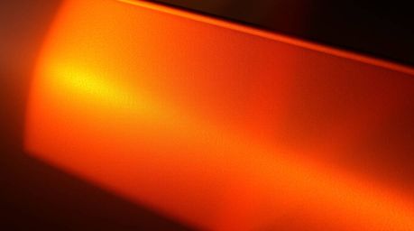 Capture the magic of warm golden hour light illuminating a metallic surface adorned with an iridescent gradient texture. This