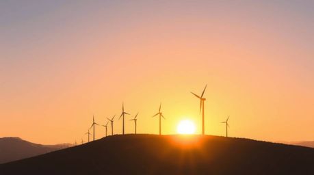 This digital painting captures a serene sunset behind a row of wind turbines atop a hill, bathed in soft pastel colors. The d