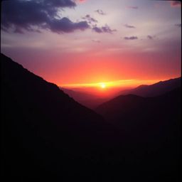 A dramatic and cinematic photograph capturing the warm, subtle darkness of a sunset over a quiet mountain valley. This soft a