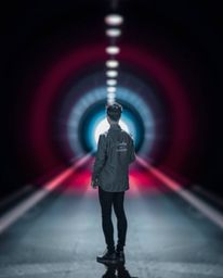 A captivating image capturing a person standing at the edge of a tunnel, their gaze fixed on the distant light. The scene is 