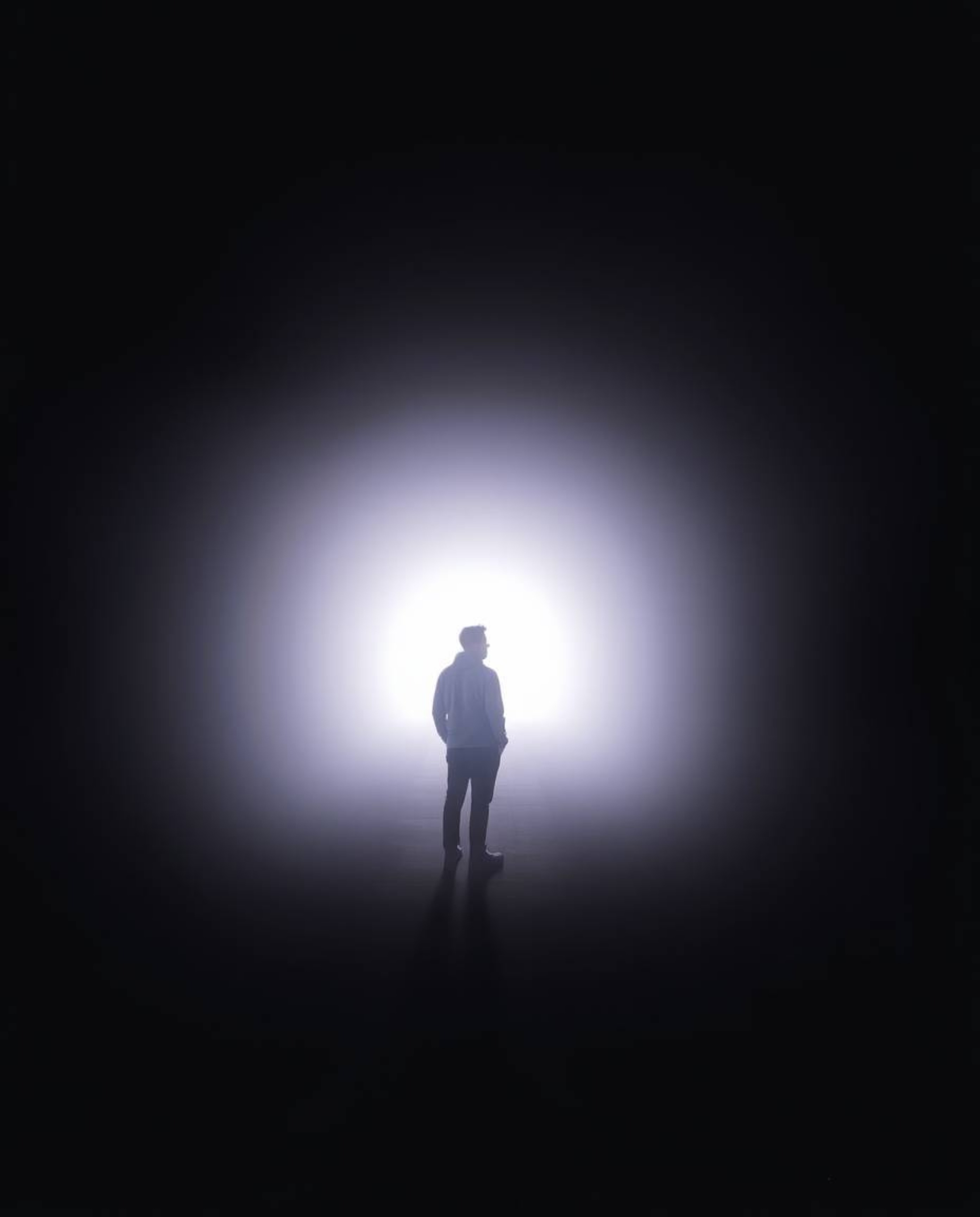 A person stands at the tunnel's edge, captivated by the gentle, soft light emanating from within. The scene exudes a dreamy a