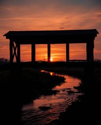 An extreme macro close-up captures the intricate details of an old wooden bridge over a river at sunset. The image is rendere