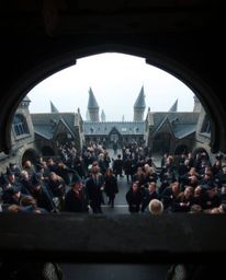 Capture the enchanting atmosphere of a magical school teeming with young wizards from a unique high-angle perspective. This i