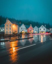 A captivating watercolor painting depicts a sleepy town's charming pastel houses under a drizzling rain.  The long-exposure s