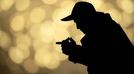 A silhouetted thief stands against a blurred bokeh background, the scene brought to life with layered papier-mâché texture an